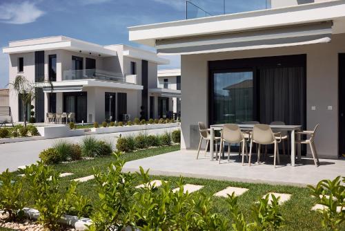 a rendering of a house with a table and chairs at Nefeli & Nefeli Luxury Residential Complexes in Ofrínion