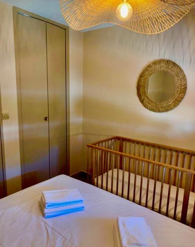 une chambre avec un berceau avec un miroir et des serviettes dans l'établissement Marina très belle vue avec ponton, au Grau-du-Roi