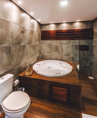 a bathroom with a toilet and a bath tub at @Casa.Mauii - Ilha do Guajiru Luxurious House in Itarema