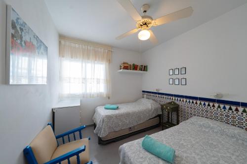 a bedroom with two beds and a ceiling fan at Puri y Lucia in San José