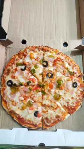 a pizza sitting in a box at Karma Hostel in Khajurāho