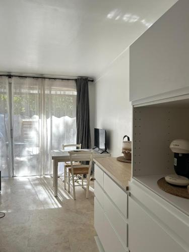 une cuisine avec une table et une salle à manger dans l'établissement Golfe de Saint Tropez, Evasion ensoleillée, 1 chambre , 1 canapé lit , terrasse, à Gassin