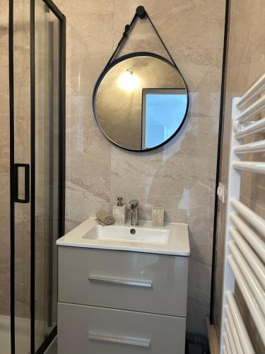 une salle de bain avec un lavabo et un miroir dans l'établissement Golfe de Saint Tropez, Evasion ensoleillée, 1 chambre , 1 canapé lit , terrasse, à Gassin