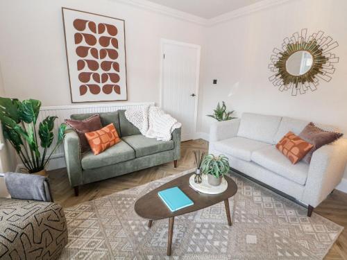 a living room with two couches and a table at 37 Berry Hill Lane in Mansfield