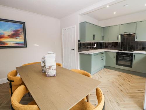 a kitchen with a wooden table and chairs at 37 Berry Hill Lane in Mansfield