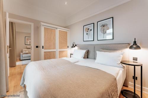a bedroom with a large white bed with two pillows at Strandhotel Kurhaus Juist in Juist
