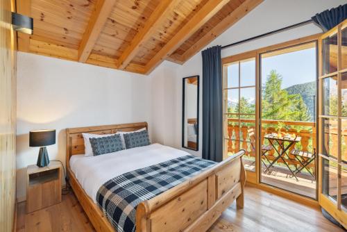 RiddesChalet Belle Vue – Alpine Charm with a View to Remember的一间卧室设有一张床和一个阳台