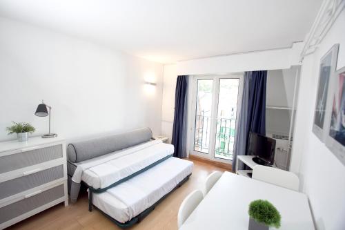ein Wohnzimmer mit einem Sofa und einem TV in der Unterkunft Apartamentos Jauregui in Hondarribia