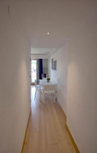 a white room with a table and a chair at Apartamentos Jauregui in Hondarribia