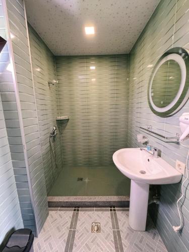 a bathroom with a shower and a sink and a mirror at Sunny days Kobuleti in K'obulet'i