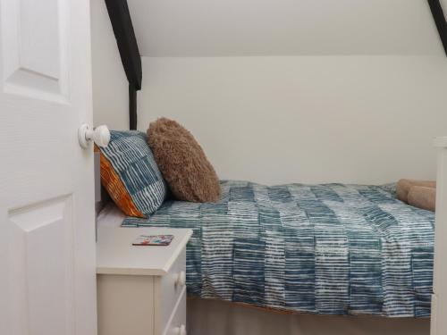 a bedroom with a bed with a teddy bear on it at Dellcote in Yelverton