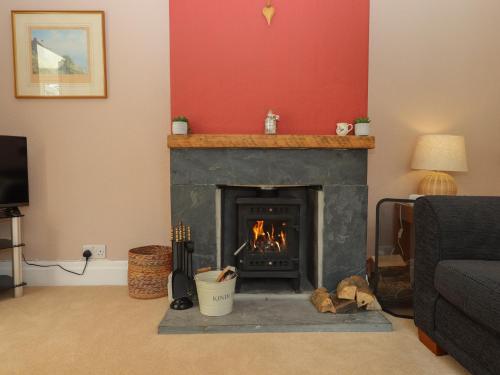a living room with a fireplace with a fire at Dellcote in Yelverton