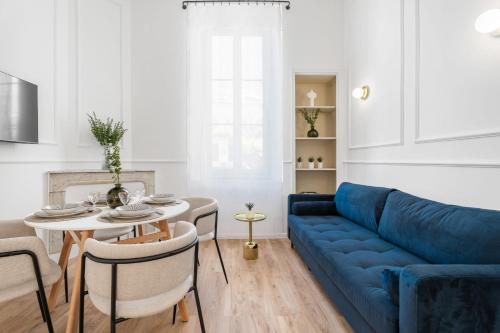 un salon avec un canapé bleu et une table dans l'établissement Appartement Prado - Welkeys, à Cannes