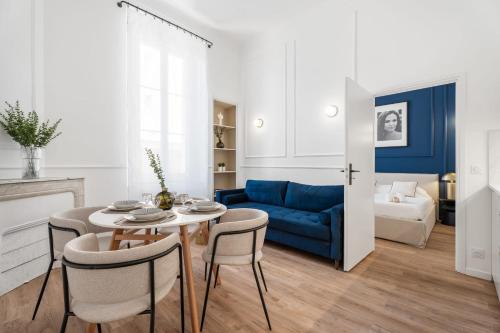 un salon avec une table et un canapé bleu dans l'établissement Appartement Prado - Welkeys, à Cannes