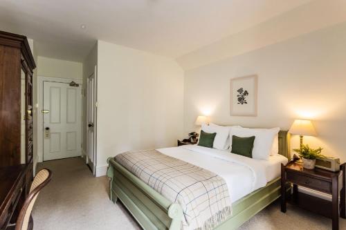 a bedroom with a large white bed and a table at Craigellachie Hotel of Speyside in Craigellachie