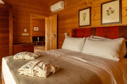 a bedroom with a bed in a log cabin at Posestvo Pule Equestrian Estate in Trebelno