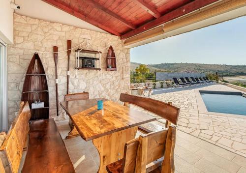 a dining room with a table and a view of a pool at Villa Maritime - Exklusive Strandvilla mit beheiztem Pool, Grillhütte & Meerblick bei Zadar in Ljubač