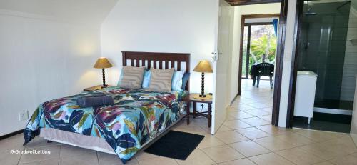 a bedroom with a bed and two lamps on a table at Beachwood Cottage in Margate