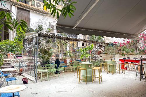 een restaurant met tafels, stoelen en planten bij Industrial-Style Apt in Psyrri, Walk to Acropolis in Athene