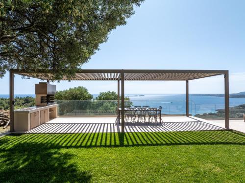 a pavilion with a table and chairs on a lawn at Echos Villa in Argostoli