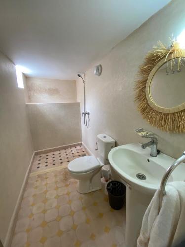 a bathroom with a toilet and a sink and a mirror at Agafay Toubkal View in Imlil