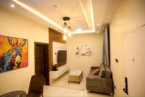 a living room with a couch and a tv at Abram Hills Hotel Ltd in Koforidua