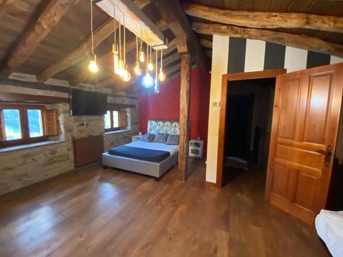 a bedroom with a bed in a room with wooden floors at Cabaña Pasiega Lucas in Bustantegua