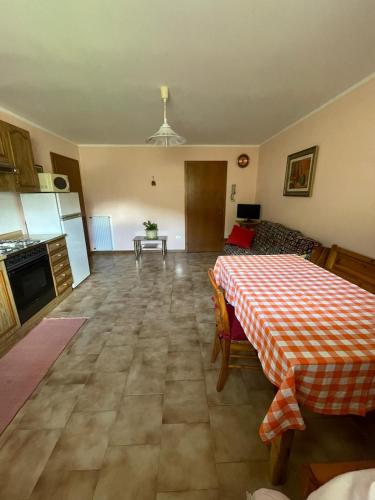 a living room with a table and a kitchen at Appartamento Bonomelli in Enguiso