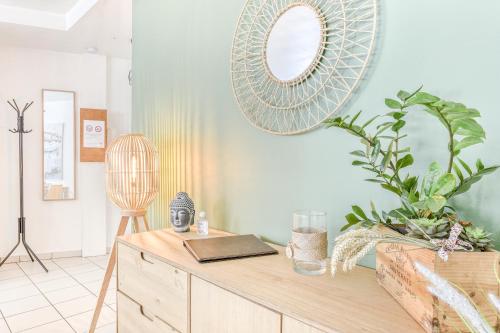 a room with a wooden dresser with a mirror on the wall at Cosy T2 à 100m de la Gare, parking gratuit, WiFi Fibre pour 4 personnes in Saint-Cyr-lʼÉcole