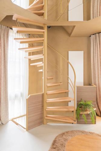 a room with a loft bed with wooden stairs at Lotz - one-of-a-kind boutique center suite in Amsterdam