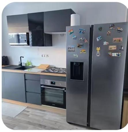 - une cuisine avec un réfrigérateur en acier inoxydable et des aimants dans l'établissement Lili Berges du Canal, à Béziers