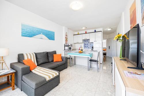 a living room with a couch and a kitchen at Holiday Dream Maspalomas in Maspalomas