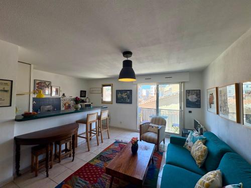 un salon avec un canapé bleu et une table dans l'établissement Cosy T2 avec balcon au Mourillon, à 1OOm de la plage, à Toulon