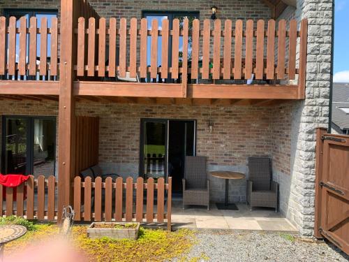 a patio with a wooden deck and a table and chairs at B&B Au Coeur de Villers in Villers-Sainte-Gertrude