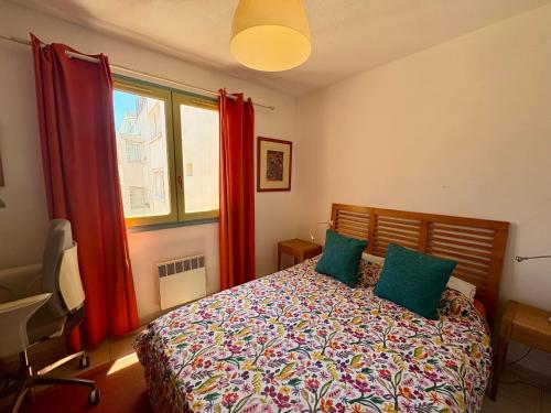 une chambre avec un lit avec des oreillers verts et une fenêtre dans l'établissement Cosy T2 avec balcon au Mourillon, à 1OOm de la plage, à Toulon