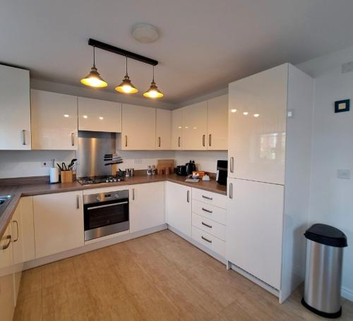 a white kitchen with white cabinets and appliances at 3 bed house Stratford-upon-Avon, River, Theatre and Restaurants in Stratford-upon-Avon