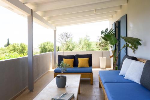 a living room with blue couches on a balcony at Villa Primarosa in Metaxáta