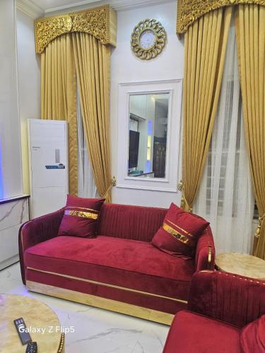 a living room with a red couch and a window at Luxury 3 bed rooms villa in Lekki