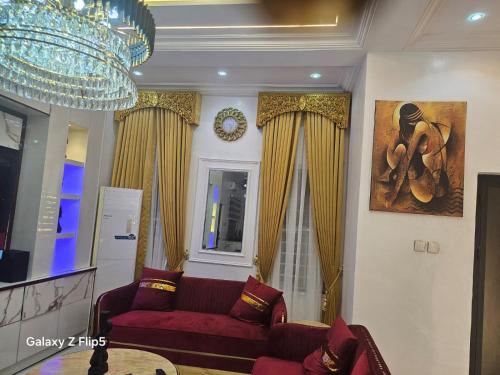 a living room with a red couch and a chandelier at Luxury 3 bed rooms villa in Lekki