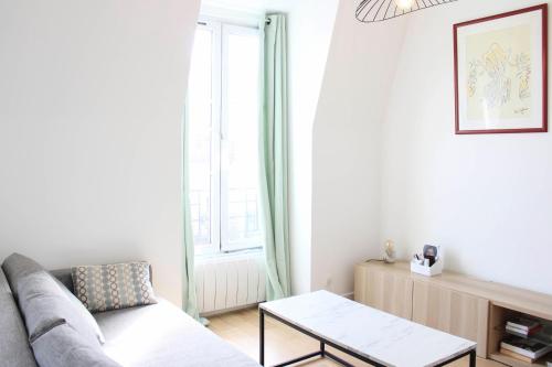 un salon avec un canapé et une table dans l'établissement Apartment 2p with Wifi near Paris, à Clichy