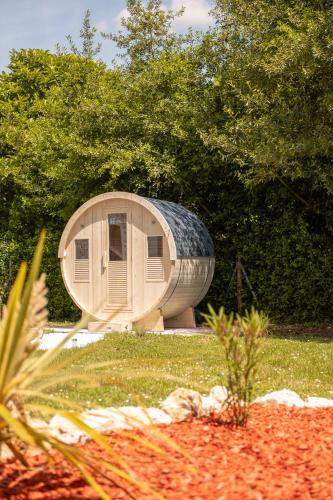 a round building with a roof on the grass at Burbujas de amor - gîte avec spa et sauna privatifs in Loubès-Bernac