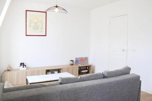 un salon avec un canapé et une table dans l'établissement Apartment 2p with Wifi near Paris, à Clichy
