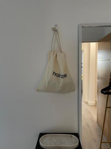 a white bag hanging from a wall next to a toilet at Sunbeam House 2 Morecambe Accessible in Morecambe