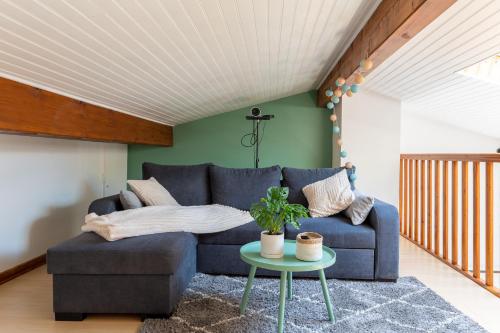 a living room with a blue couch and a table at Burbujas de amor - gîte avec spa et sauna privatifs in Loubès-Bernac