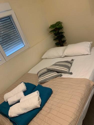 a bed with two pillows and towels on it at RAY APARTMENT in Flogita