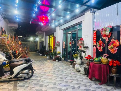 a scooter parked in front of a building with flowers at Homestay Sunny in Thái Nguyên