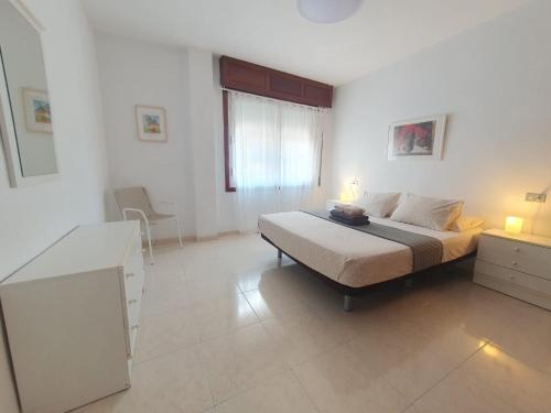 une chambre avec un lit, un bureau et une fenêtre dans l'établissement alquilaencanarias El Medano junto a la Playa, à El Médano