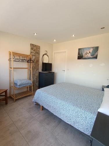 a bedroom with a bed and a chair at Pension Doña Lubina in Finisterre