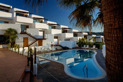 un hotel con piscina frente a un edificio en Boutique Hotel El Tio Kiko en Agua Amarga