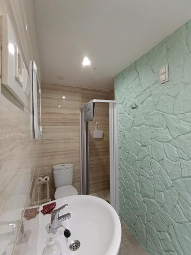 a bathroom with a sink and a shower and a toilet at Pension Doña Lubina in Finisterre